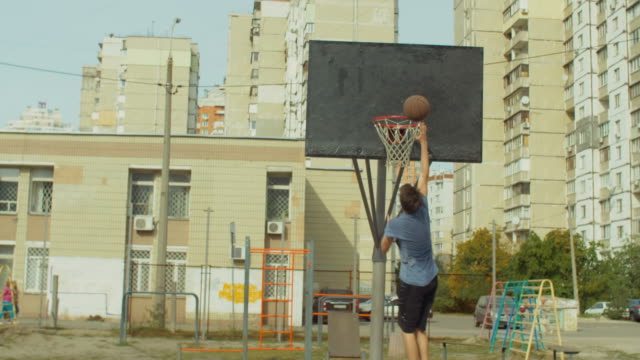 Man-practicing-layup-shot-on-basketball-court