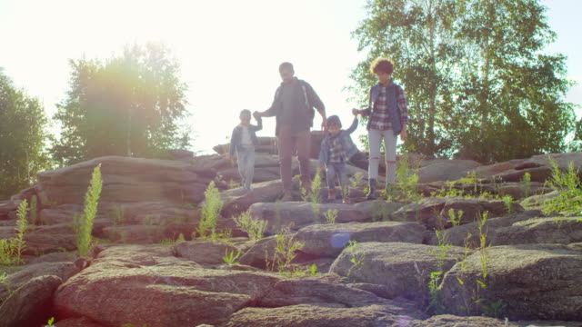 Familia-activa-con-niños-caminando-por-las-rocas