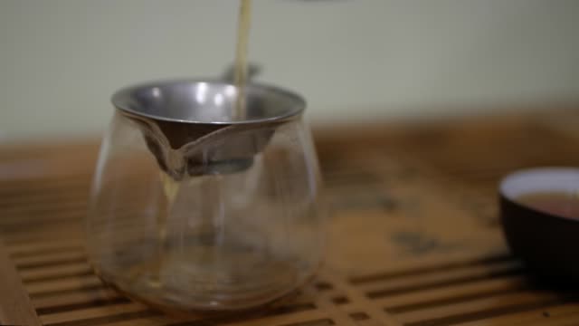 I-pour-tea-into-the-chahai-through-a-sieve.-Chinese-tea-ceremony.
