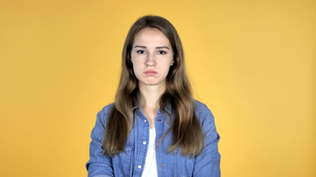 Pretty-Woman-Shaking-Head-to-Reject-Isolated-on-Yellow-Background