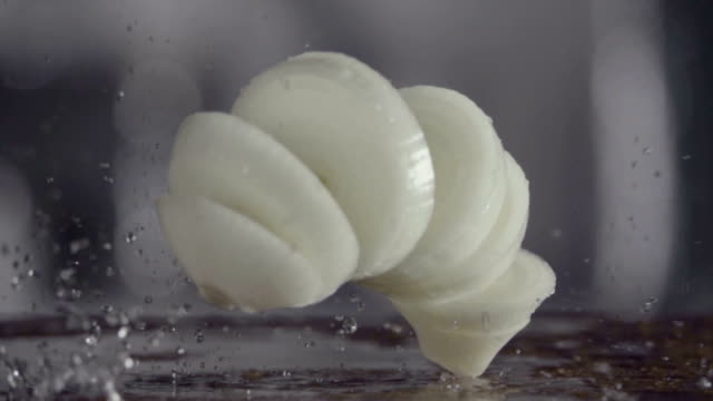 Falling-of-sliced-white-onion-into-the-wet-table.-Slow-motion-480-fps