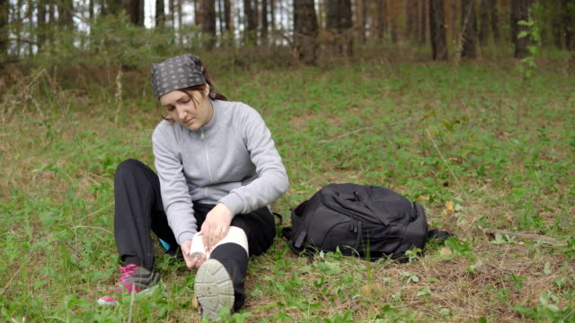 junge-Frau-macht-sich-erste-Hilfe-nach-der-Verletzung-selbst-im-Wald
