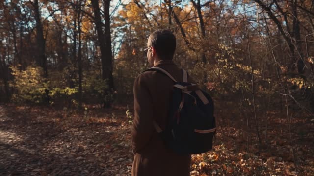 Allein-gut-aussehender-Mann-geht-durch-Wald-in-Herbsttag,-Kamera-bewegen