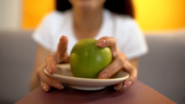 Person-dient-Apple-zu-hungern-Mädchen,-strengen-Veganismus-und-Mangel-an-Vitaminen,-Ernährung
