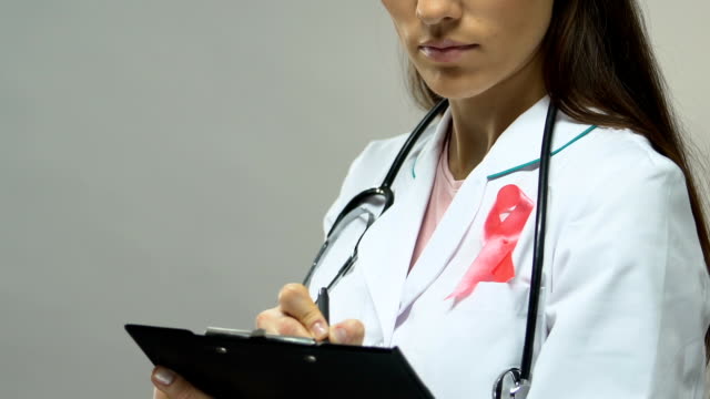 Médico-con-cinta-rosa-prescribir-tratamiento,-lucha-contra-el-cáncer-de-mama