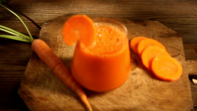 Karotten-Saft-im-Glas-auf-Tisch