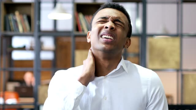 Schwarzen-Mann-im-Büro-mit-Nackenschmerzen-müde