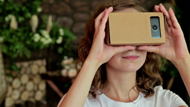 Young-curly-woman-using-Virtual-Reality-Glasses