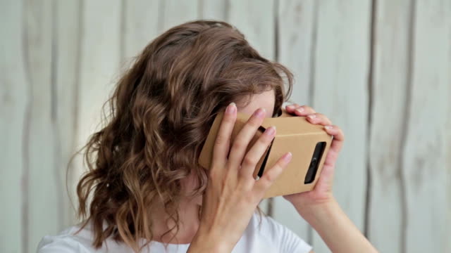 Joven-mujer-rizada-utilizando-gafas-de-realidad-Virtual