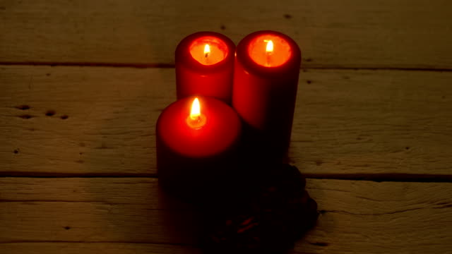 Luz-de-velas-rojas-y-rosas-en-el-escritorio-de-madera-blanco