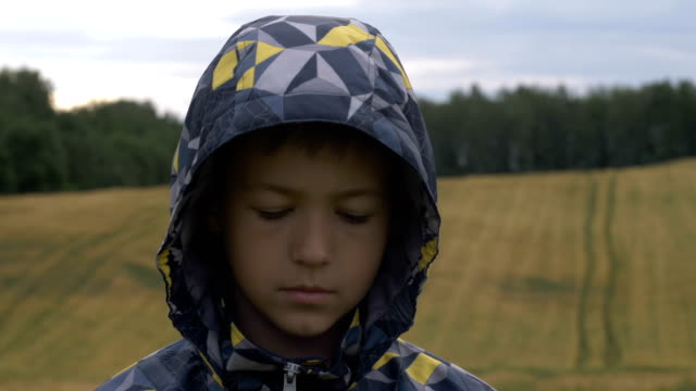 refugee-boy-looks-down,-homeless-boy,-pain-on-face
