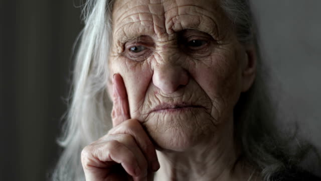 Portrait-of-old-woman-with-grey-hair-telling-story.