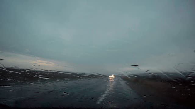 Regentropfen-auf-dem-Fenster.-Zusammenfassung-Hintergrund-des-Autos-Scheinwerfer-bewegen-Weg