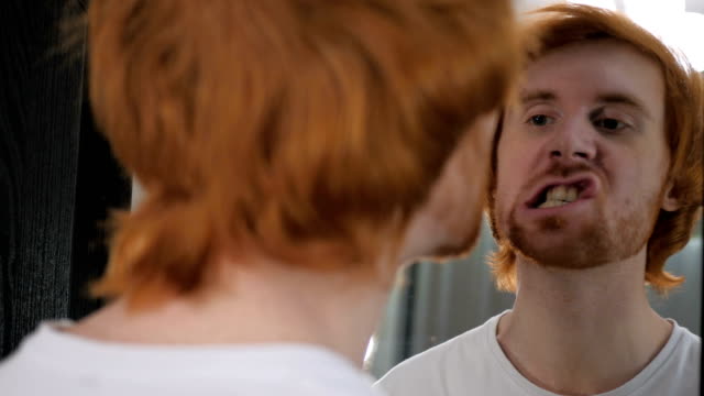 Redhead-Beard-Man-Looking-at-His-Face-in-Mirror