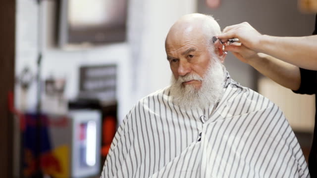 Professional-stylist-makes-hairstyle-to-senior-man