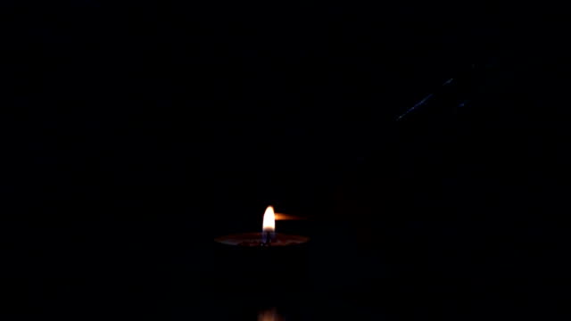 Lighting-a-match-stick-from-a-candle,-slow-motion