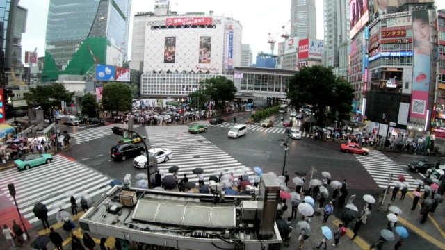4K-Time-lapse-of-people-with-umbrellas-cross-the-famous-diagonal-intersection-in-Shibuya,-Tokyo,-Japan