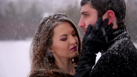 Pareja-en-ropa-de-color-negro-bajo-la-nieve.-De-la-boda.