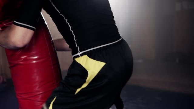 Kämpfer-schlagen-dummy-Boxsack-im-Fitness-Studio-während-des-Übens-Kampftechnik