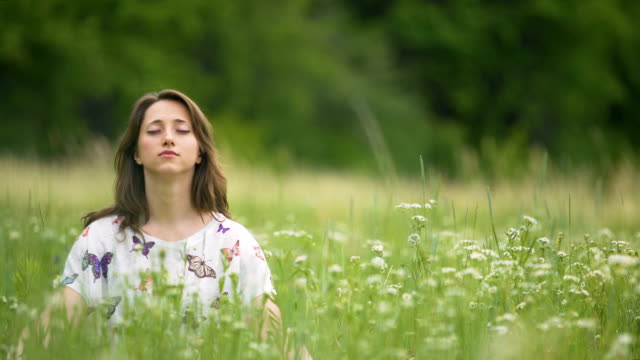 Junge-Frau-meditieren-im-hohen-grünen-Rasen,-Einssein-mit-der-Natur,-aufhören-zu-denken,