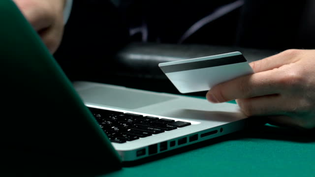 Male-hands-typing-on-laptop-man-inserting-his-credit-card-number,-online-banking