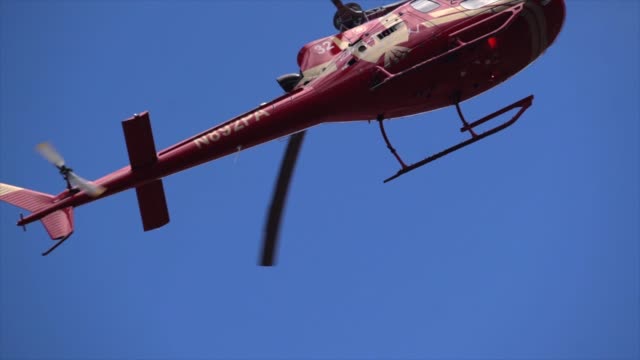 Slow-Motion,-die-roten-Hubschrauber-fliegt-über-Kopf-gegen-ein-strahlend-blauer-Himmel-hautnah