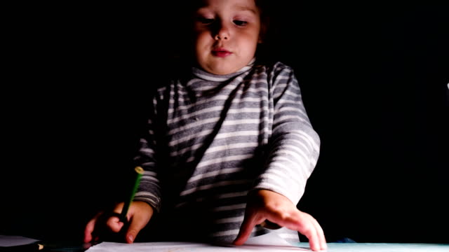 Baby-girl-draws-with-a-pencil-and-shows-a-drawing,-closeup