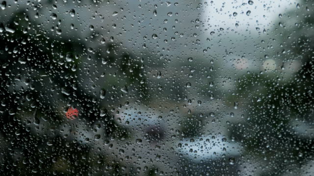borrosa-la-vista-de-tráfico-a-través-de-un-parabrisas-de-coche-cubierto-de-la-lluvia-de-fondo