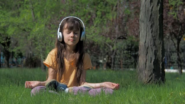 Girl-with-headphones-in-lotus-pose.