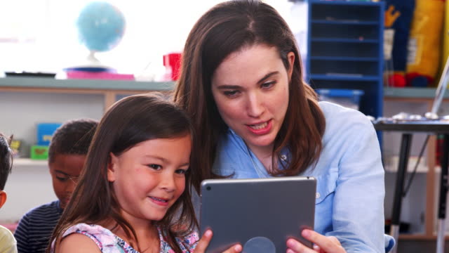 Lehrer-und-Mädchen-in-der-Grundschule-Klasse-mithilfe-der-Tablet-computer