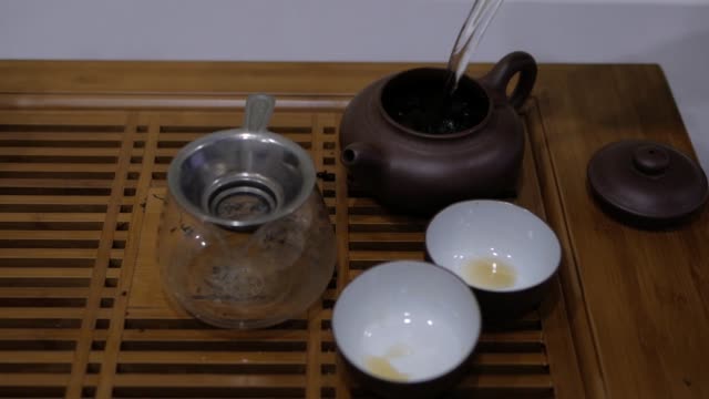 Gießen-Sie-heißes-Wasser-in-den-Ton-Teekanne.-Chinesische-Tee-Zeremonie.