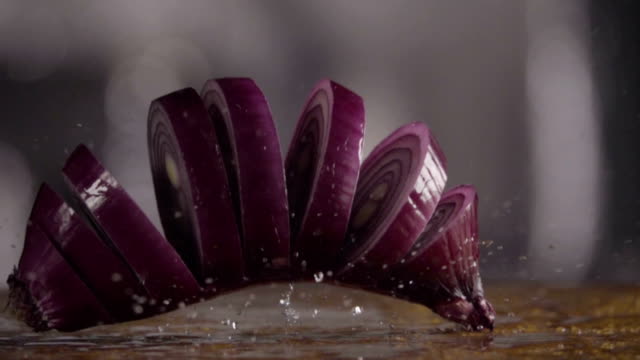 Falling-of-sliced-red-onion-into-the-wet-table.-Slow-motion-480-fps