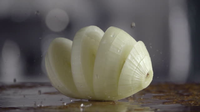 Falling-of-sliced-white-onion-into-the-wet-table.-Slow-motion-240-fps