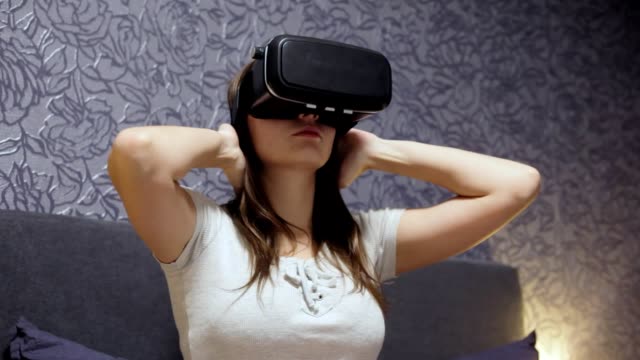Schöne-junge-Frau-trägt-VR-Kopfhörer-im-Schlafzimmer.-Schaut-sich-um.-Video-wird-VR,-VR-Spiel-zu-spielen.