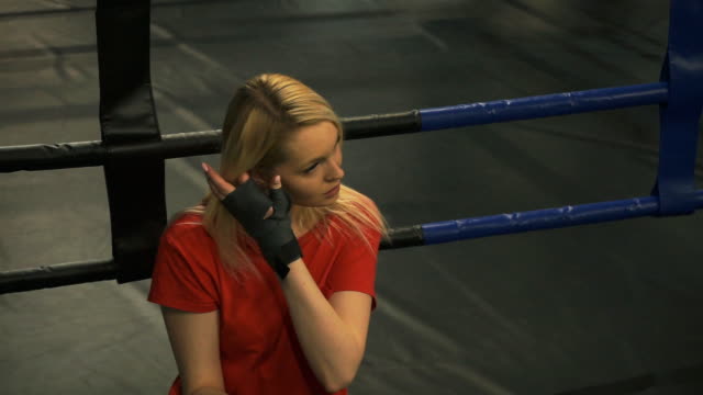 Beautiful-tired-blonde-sitting-in-the-ring-after-training