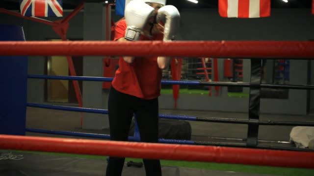Una-niña-en-un-casco-y-guantes-de-boxeo-entrena-cuestas