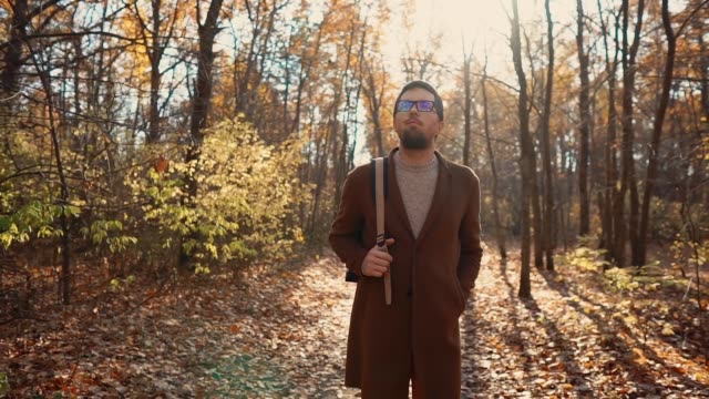 Gut-aussehender-Mann-mit-Brille,-ein-Spaziergang-im-Herbstwald-tagsüber-umzusehen