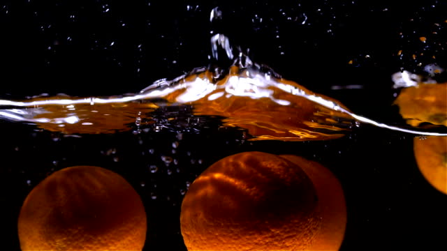 Oranges-fall-into-water-in-slow-motion