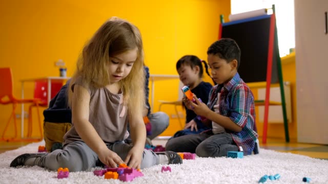 Kindergarten-Mädchen-spielen-mit-bunten-Klötzchen