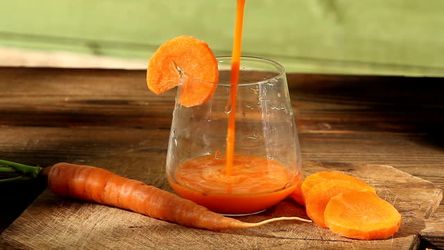 Karotten-Saft-im-Glas-auf-Tisch