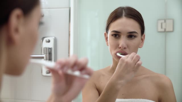 Salud-dental.-Mujer-cepillado-de-los-dientes-en-el-baño
