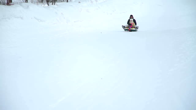 Mother-and-Daughter-Riding-on-a-Sledding-Tubing