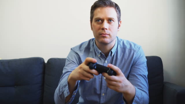 Man-playing-shooter-video-game-on-TV.-Gamepad-controller-in-hands.