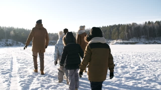 Familia-caminando-en-el-sol-brillante-en-invierno