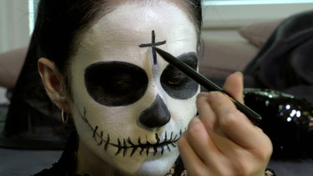 Woman-finishing-Day-of-the-Dead-make-up-close-up