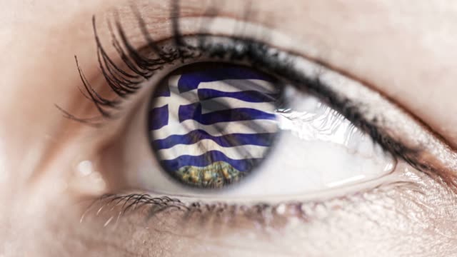 mujer-ojo-verde-en-primer-plano-con-la-bandera-de-Grecia-en-el-iris-con-el-movimiento-del-viento.-concepto-de-vídeo