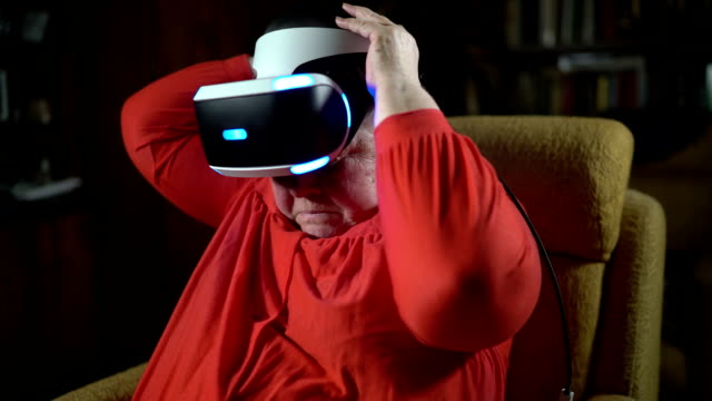 Elderly-woman-wearing-VR-headset-in-front-of-TV-screen
