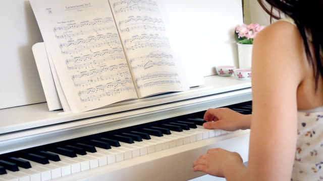 Junge-Brünette-Frau-ist-das-Klavierspiel-in-hellen-Raum,-von-hinten,-Hand-held