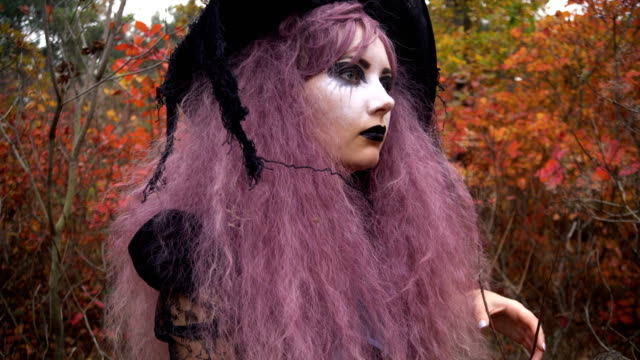 Jóvenes-rosa-bruja-de-pelo-encontrada-raro-reactivo-en-el-místico-bosque-de-otoño.-Preparación-de-Halloween.