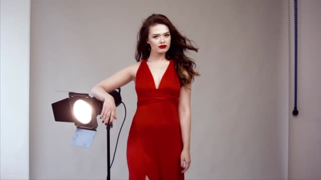 Hermosa-modelo-posando-en-vestido-rojo-en-estudio-fotográfico.